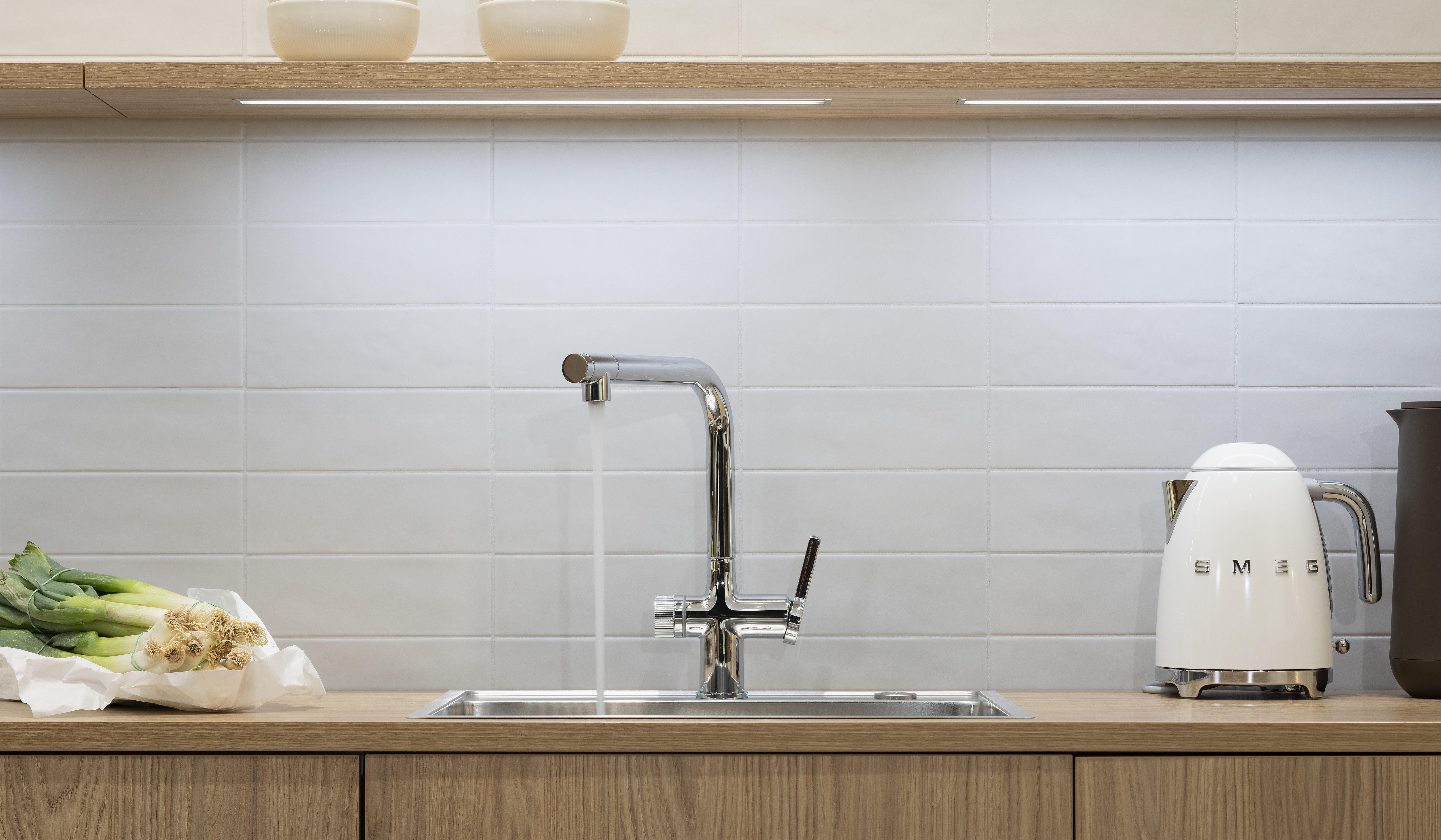 APL: TOP Granit Perlato und Goldeiche Front: neoLEAF Goldeiche Korpus: Graphit Griff: PTO und Ziergriff Weiß matt  Geräte: AEG Armatur: Reginox Spüle: Reginox   Features: Echtholzfront, Fliesen, moderne Nischenplanung, Tischlösung mit Granitplatte durchgängig in Thekenlösung, Edelstahlbecken, skandinavisches Design, Designgriff, Sideboardlösung in Goldeiche, verschiedene Arbeitshöhen (Kochen + Arbeiten), stylische Lichtlösung in Nische, Gemütlichkeit durch Teppich in der Küche (Trend 2025/26),Wassersprudler