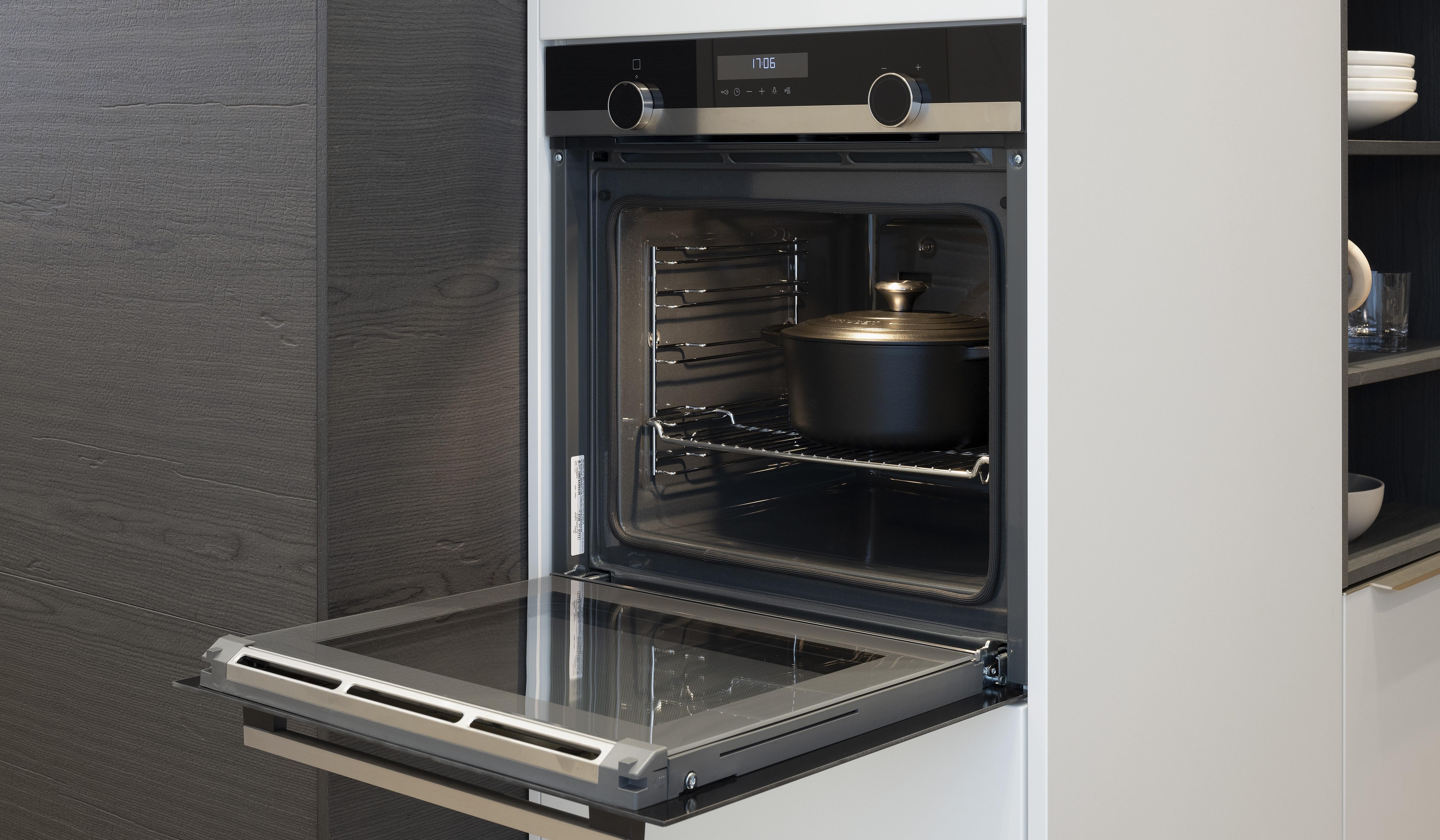 APL: Beton NP 12 mm Front: SoftLack Weiß softmatt Front: dunkles Holz NB Sepia Korpus: Weiß Griff: PTO und Edelstahloptik Geräte: Siemens, Kochfeld mit Abzug elica Armatur: Nobili Spüle: Franke    Features: Appartementküche, 90er Höhe, Materialkombi Weiß matt und dunkle Holzoptik mit Syncronpore (Oberflächenhaptik), Arbeitsplatz, Einbauschränke mit Sitzbank, Backofen in gedrehtem Schrankelement (Optik) somit kein Backofen in Küche sichtbar.