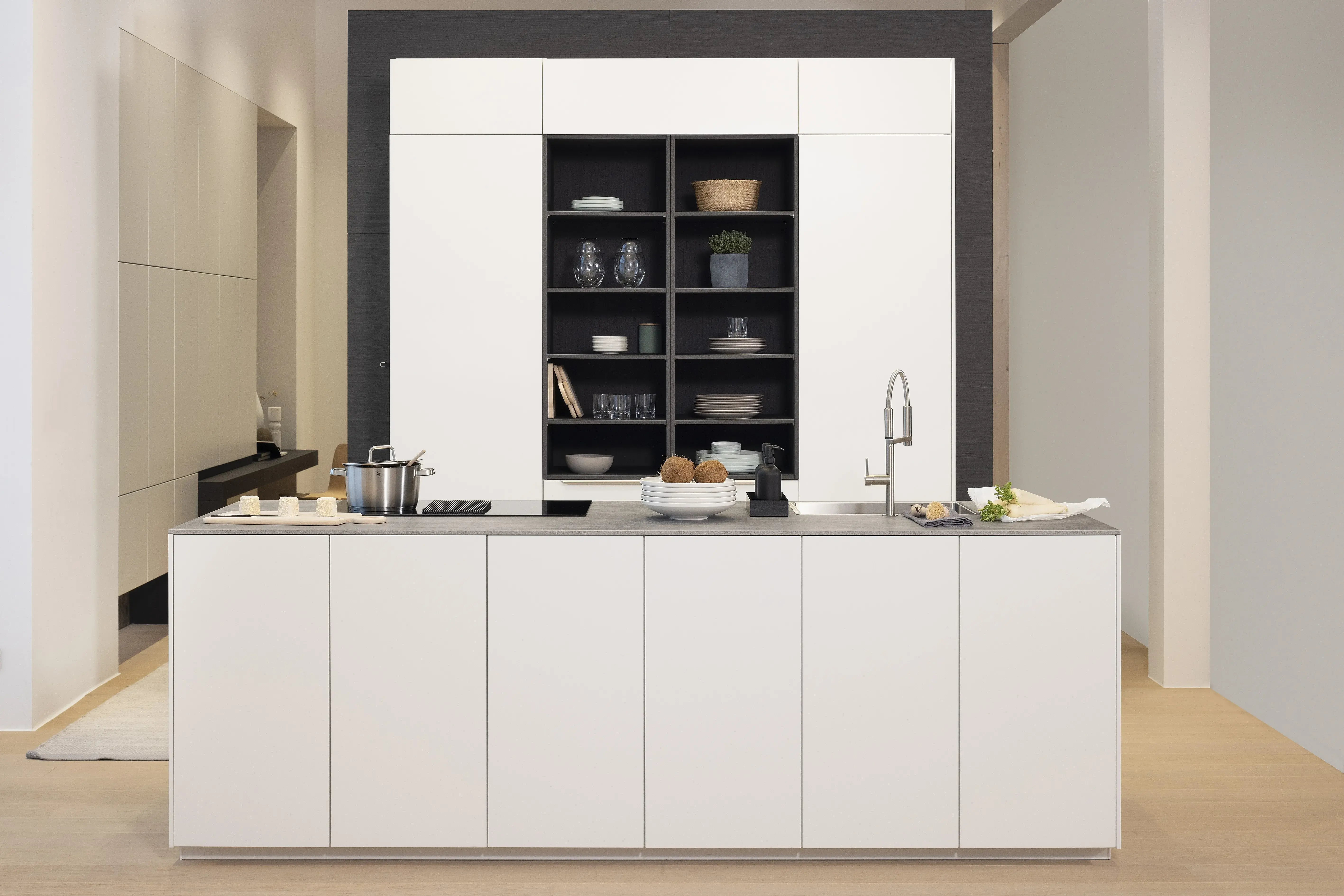 APL: Beton NP 12 mm Front: SoftLack Weiß softmatt Front: dunkles Holz NB Sepia Korpus: Weiß Griff: PTO und Edelstahloptik Geräte: Siemens, Kochfeld mit Abzug elica Armatur: Nobili Spüle: Franke    Features: Appartementküche, 90er Höhe, Materialkombi Weiß matt und dunkle Holzoptik mit Syncronpore (Oberflächenhaptik), Arbeitsplatz, Einbauschränke mit Sitzbank, Backofen in gedrehtem Schrankelement (Optik) somit kein Backofen in Küche sichtbar.