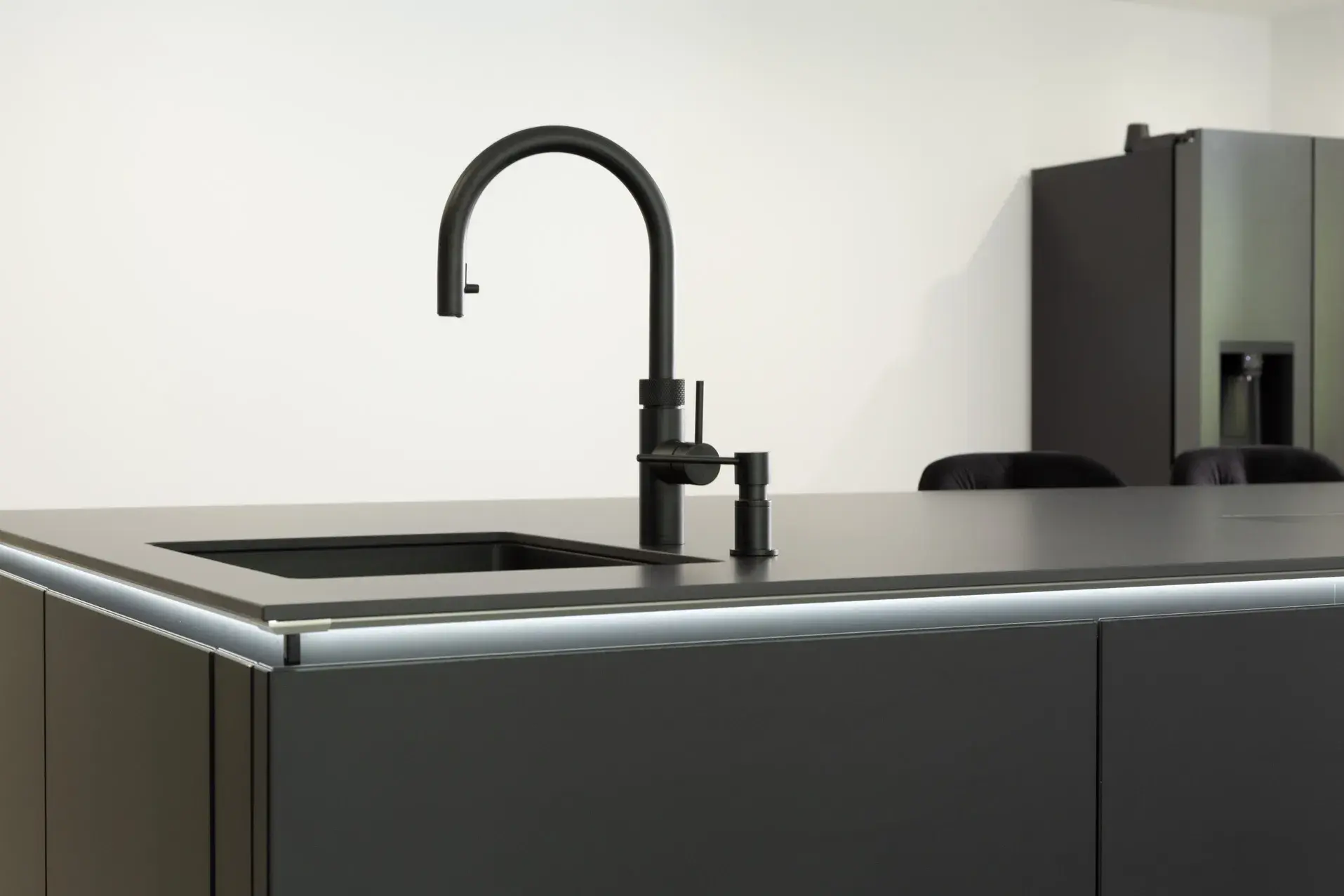 Schwarze Küche mit viel Schrankfläche - Spüle mit Armatur als Teilansicht